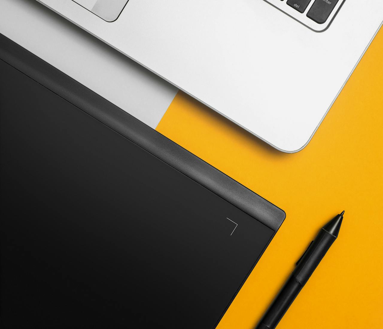 about-01 Overhead view of a laptop and graphics tablet on a colorful desk setup.